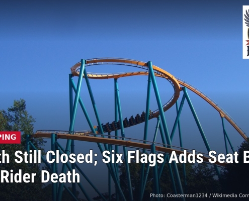 Goliath roller coaster track at Six Flags Over Georgia against a blue sky, with headline: Goliath Still Closed; Six Flags Adds Seat Belts After Rider Death